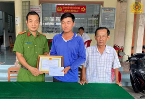 Đại diện Công an thị trấn Vũng Liêm, chính quyền địa phương thừa ủy quyền của Chủ tịch UBND huyện Vũng Liêm trao giấy khen của Chủ tịch UBND huyện cho anh Phan Chí Thảo