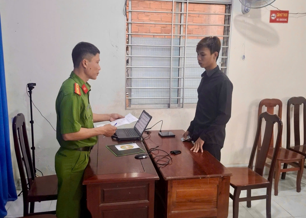 Ảnh điều tra viên đọc quyết định khởi tố bị can