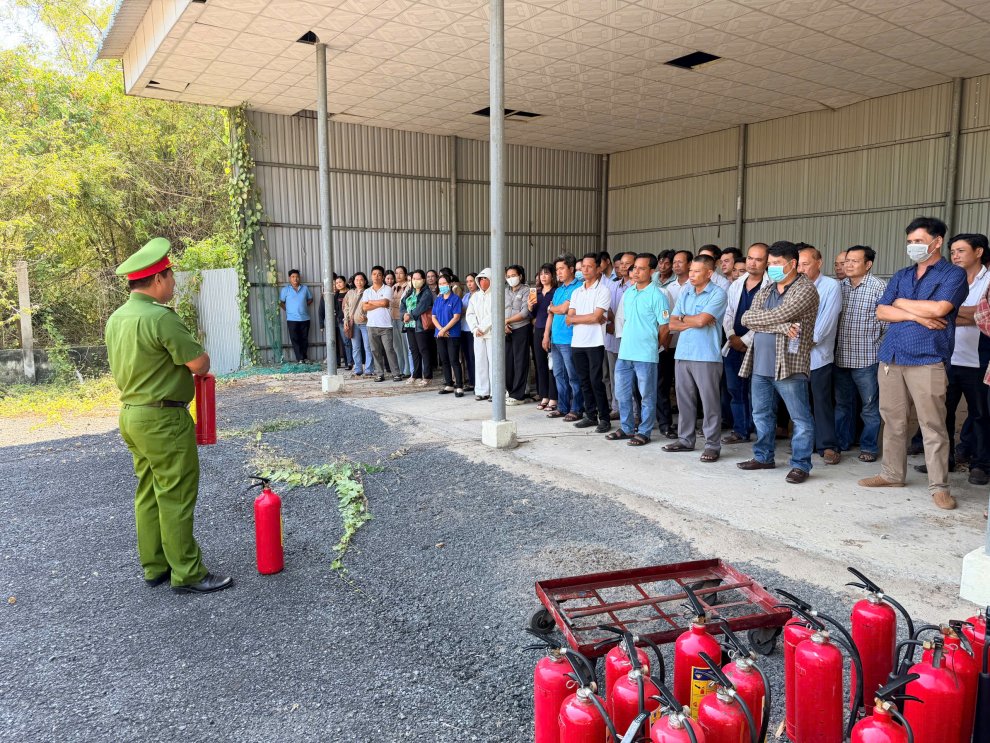 Hình 2 cán bô phòng Cảnh sát PCCC và CNCH hướng dẫn sử dụng bình chữa cháy