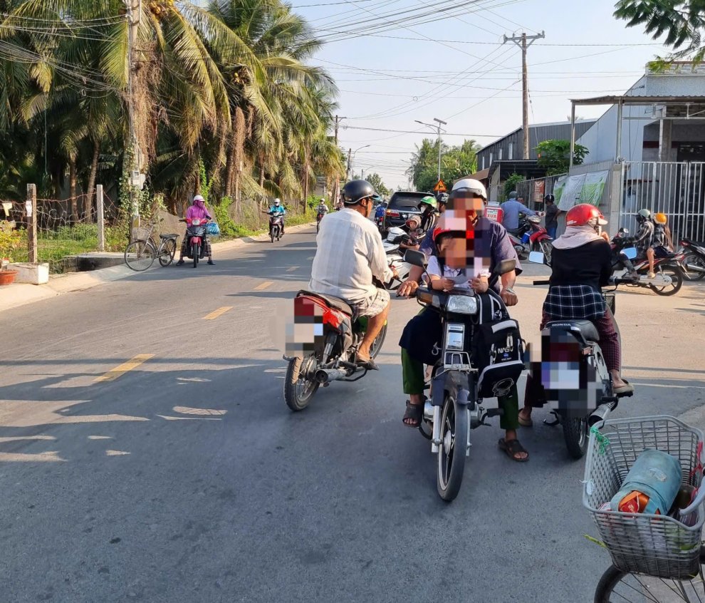 ẢNH 2 PHU HUYNH CHO HOC SINH NGOI PHIA TRUOC XE MAY