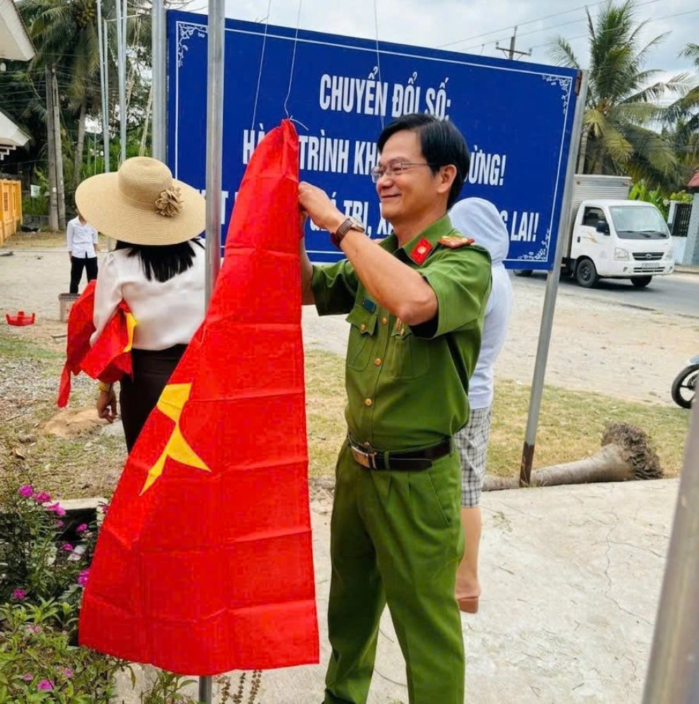 Công an xã Phước Long phối hợp thay mới cờ Tổ quốc tại Đền thờ liệt sĩ