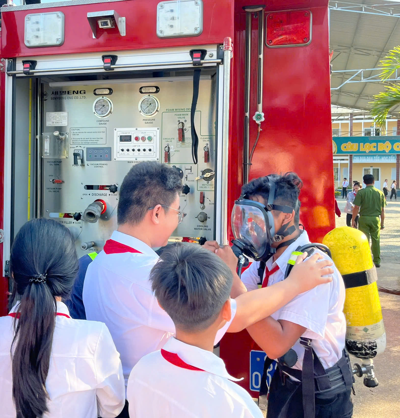 ẢNH 5 Cán bộ Đội chữa cháy và CNCH khu vực 2 giới thiệu, hướng dẫn học sinh sử dụng các trang thiết bị trên xe chữa cháy