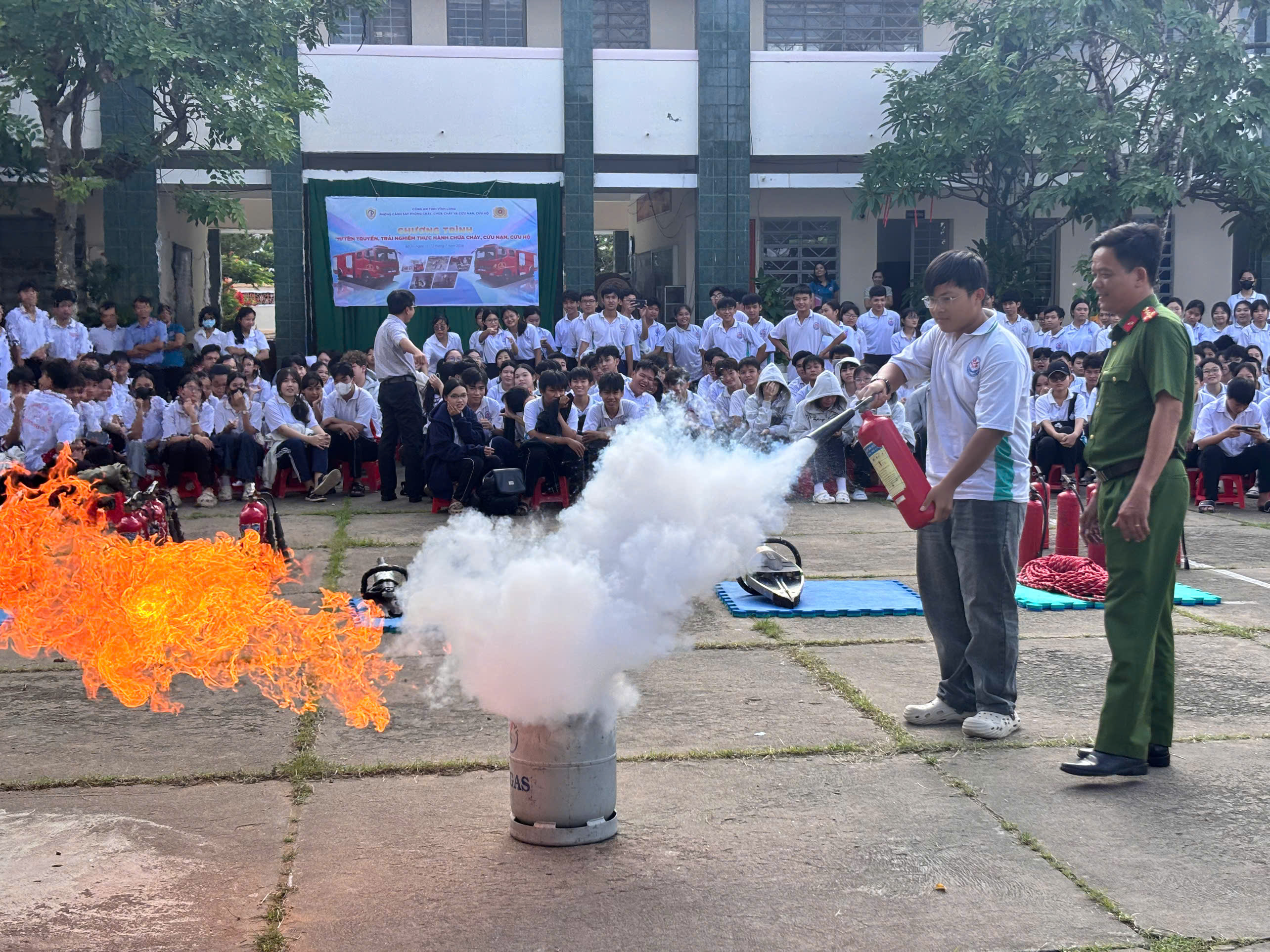 Các em học sinh thực hành sử dụng bình chữa cháy