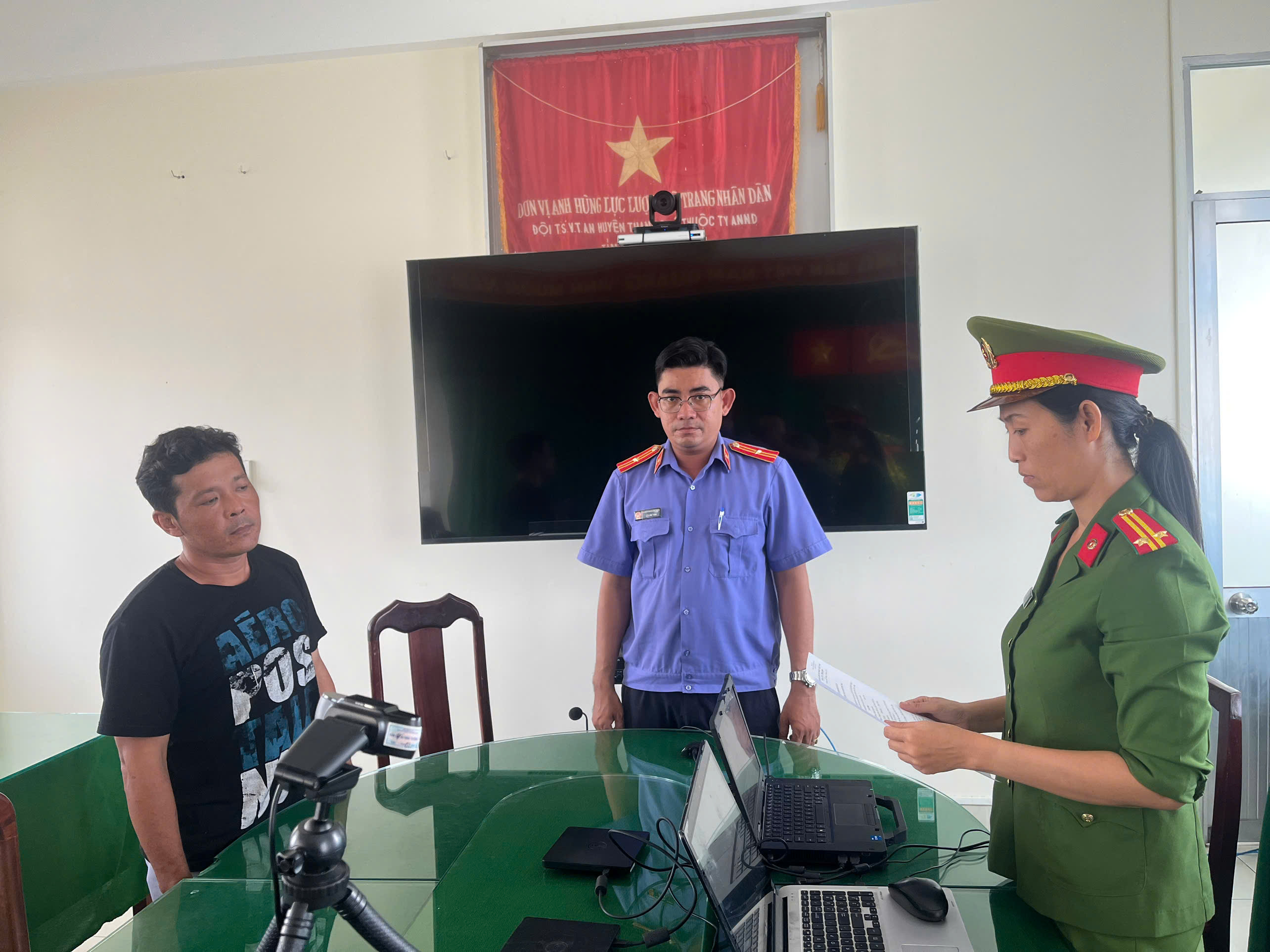 ảnh điều tra viên đọc quyết định khởi tố bị can Tạ Anh Thành